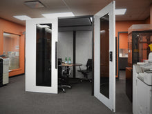 Load image into Gallery viewer, Meeting room office pod 'Tilbury XL' with chairs and round table for meetings or interviews. Made in Canada for the USA.